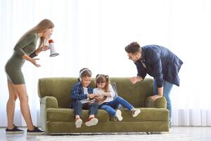 Eltern reden auf ihre Kinder ein, die auf dem Sofa sitzen
