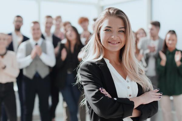 Bild vergrößern: erfolgreiche Geschäftsfrau vor dem Hintergrund einer Gruppe junger Mitarbeiter. Foto mit Kopierraum