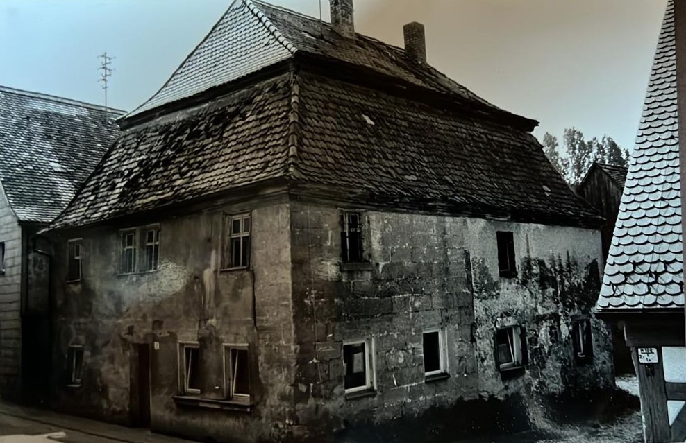 Bild vergrößern: Schwarz-Weiß-Bild. Ein zweistöckiges Steinhaus.