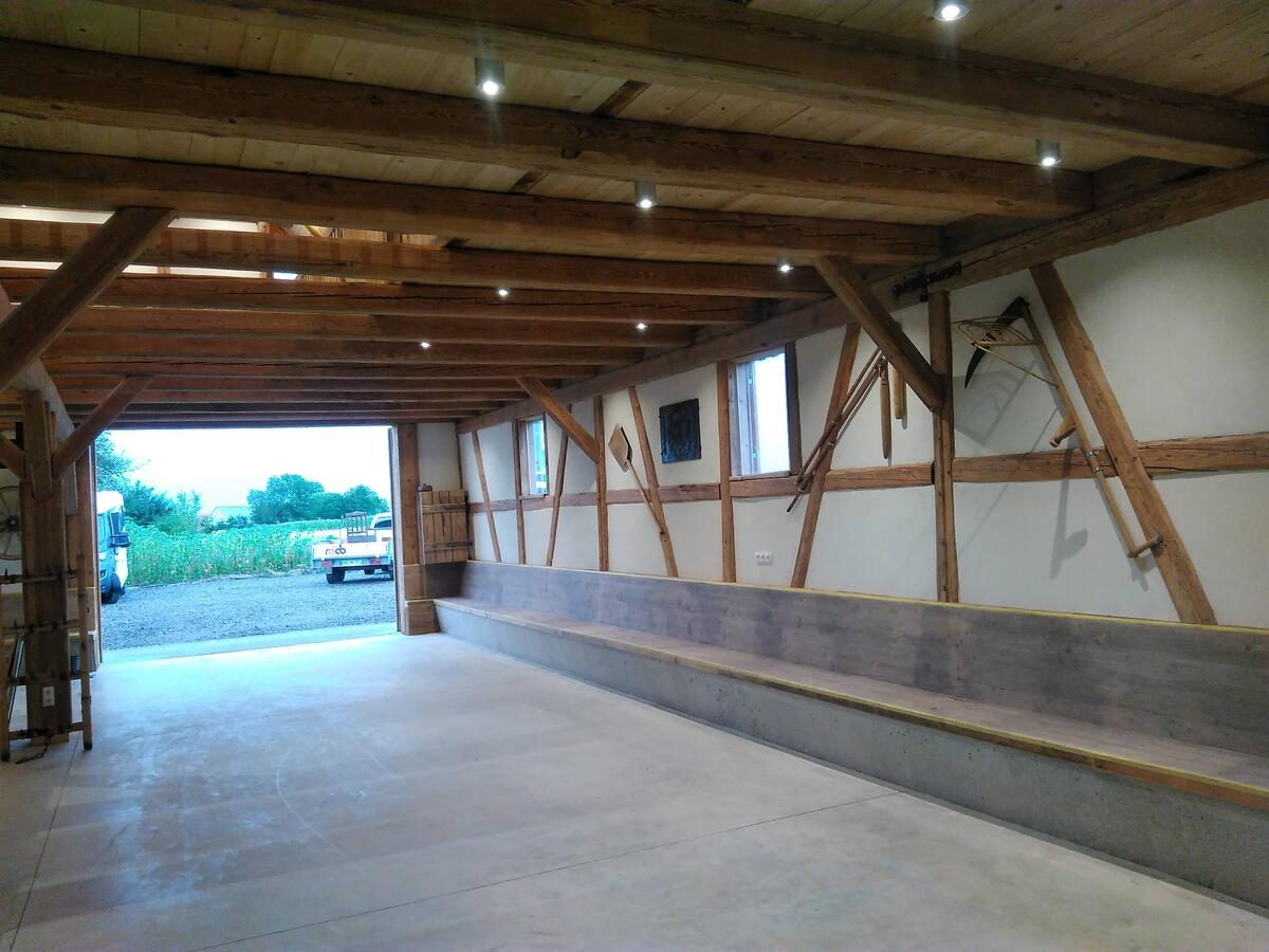 Bild vergrößern: Garage mit Fachwerkwänden. Betonboden. Der Raum hat eine Holzdecke.
