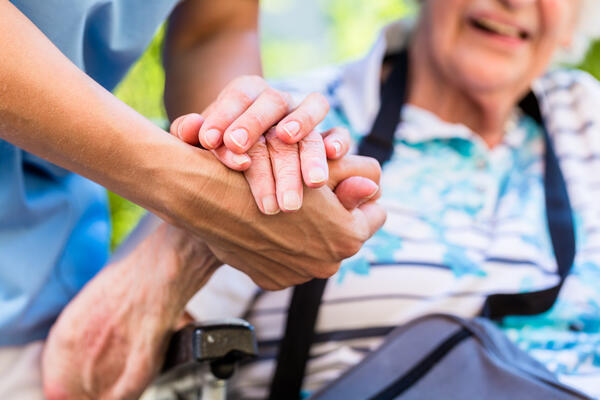 Bild vergr&ouml;&szlig;ern: Krankenschwester hält die Hand einer alten Dame